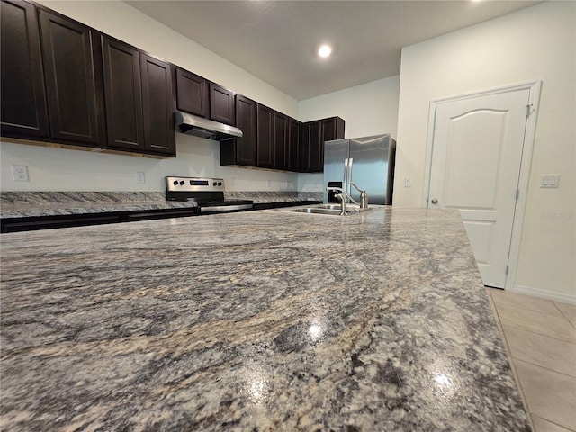 kitchen featuring dark brown cabinetry, stainless steel appliances, dark stone countertops, and sink