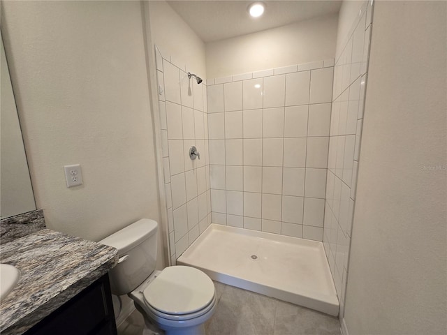 bathroom featuring tiled shower, vanity, and toilet