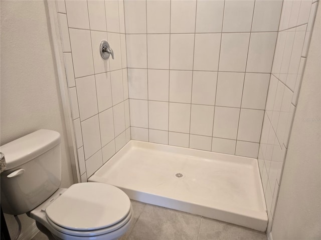 bathroom with tiled shower and toilet