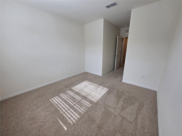 spare room featuring light colored carpet