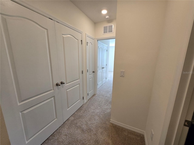 hallway featuring light colored carpet