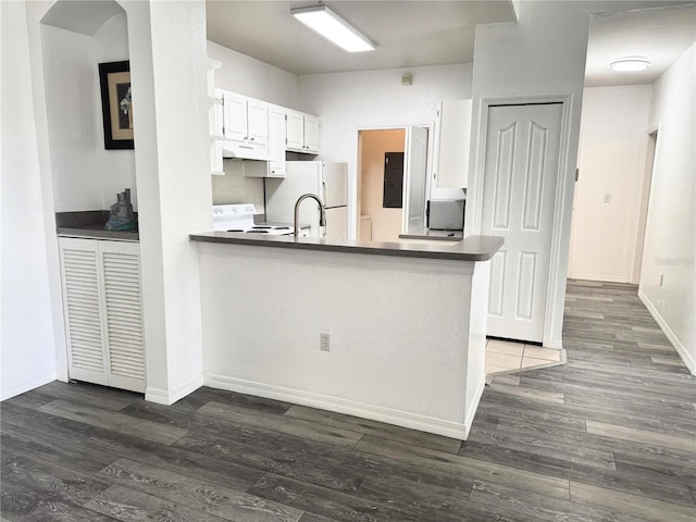 kitchen with dark hardwood / wood-style floors, white refrigerator, white cabinetry, and kitchen peninsula