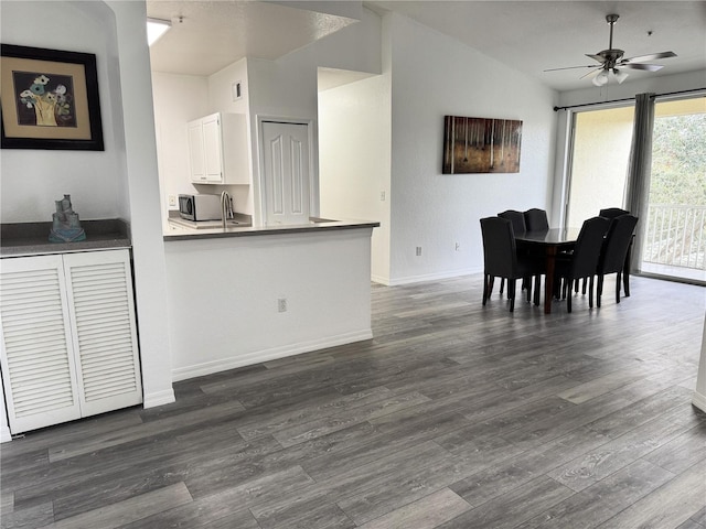 interior space featuring ceiling fan, dark wood-type flooring, and vaulted ceiling