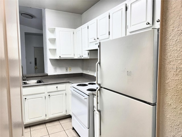 kitchen with refrigerator, sink, light tile patterned floors, white electric range oven, and white cabinetry