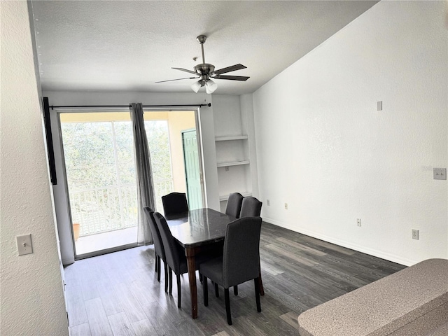 dining space with built in shelves, a textured ceiling, ceiling fan, and dark wood-type flooring