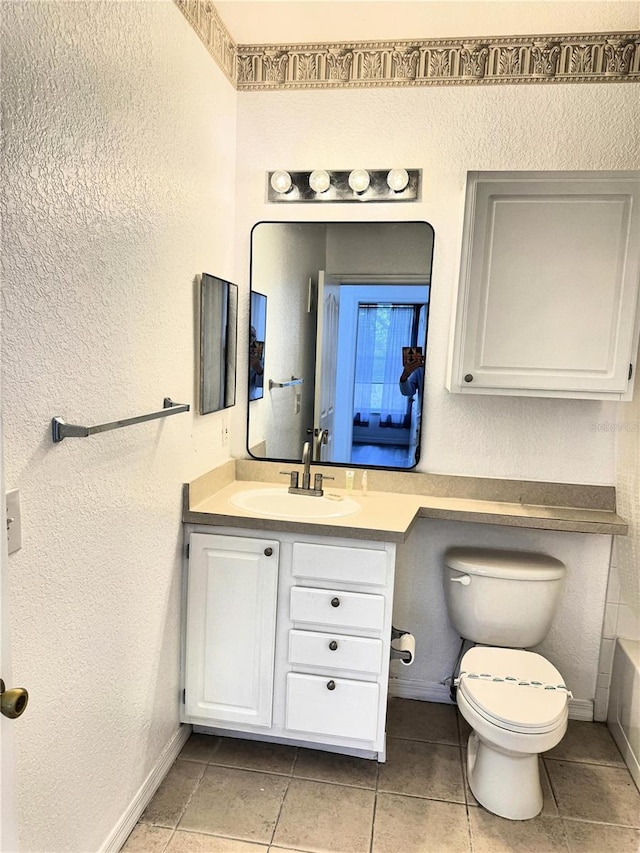 bathroom featuring tile patterned floors, vanity, toilet, and a bathing tub