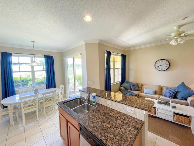 kitchen featuring sink, hanging light fixtures, crown molding, a center island with sink, and light tile patterned floors