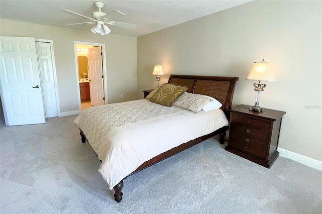 carpeted bedroom with ensuite bathroom and ceiling fan