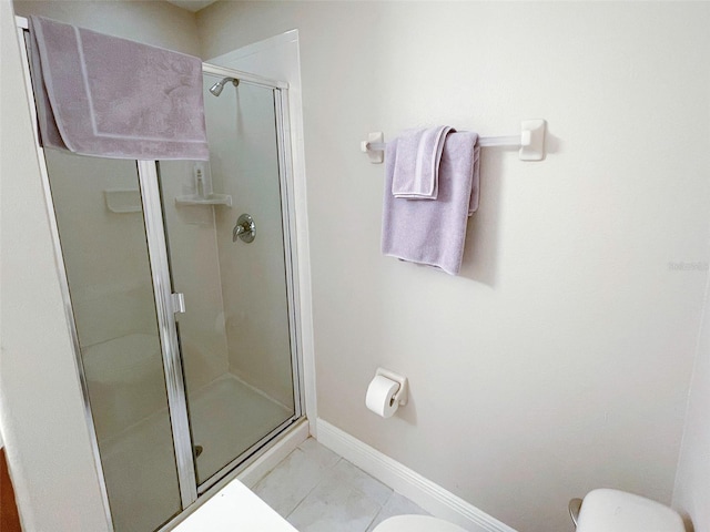 bathroom with tile patterned floors, an enclosed shower, and toilet