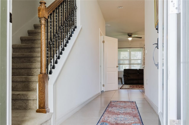 stairs featuring ceiling fan and tile patterned flooring