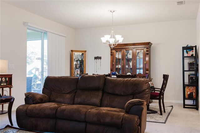 carpeted living room with an inviting chandelier