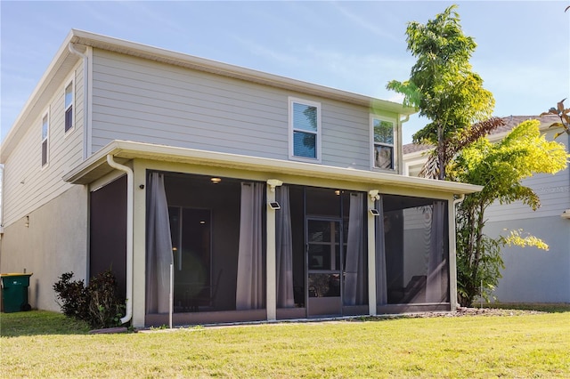 rear view of property with a sunroom and a yard