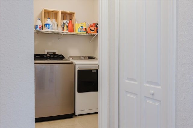 laundry room with light tile patterned floors and washing machine and dryer