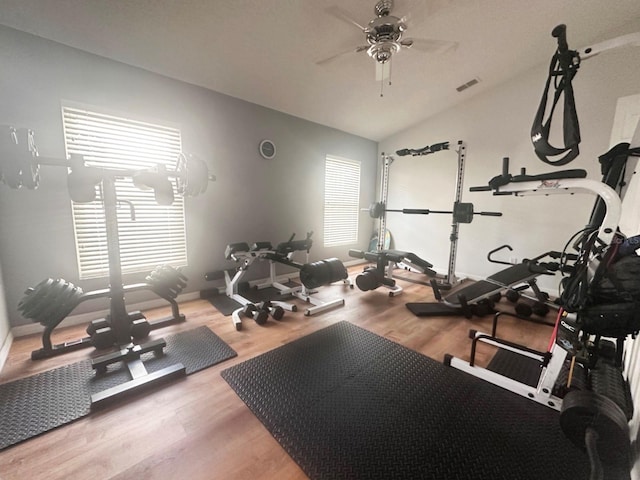 workout room featuring wood-type flooring, ceiling fan, and lofted ceiling