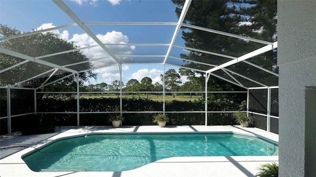 view of swimming pool with a patio area and a lanai