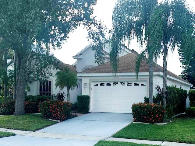 view of front of property featuring a garage and a front lawn