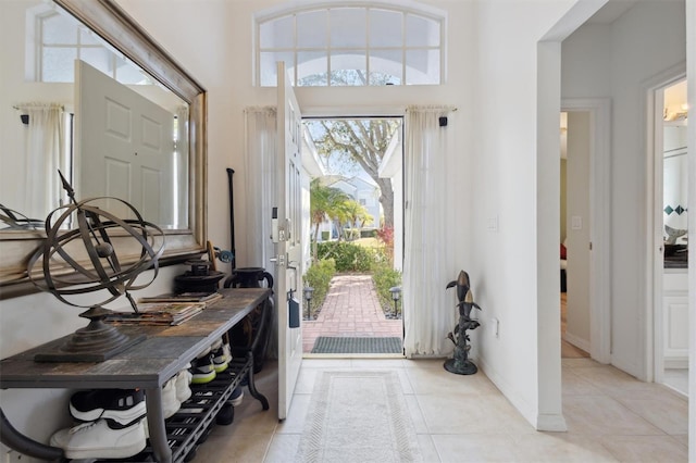 tiled foyer entrance featuring a towering ceiling