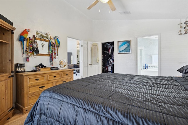 bedroom featuring ceiling fan, lofted ceiling, connected bathroom, and wood-type flooring