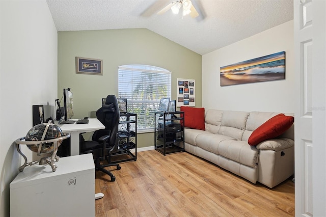 office space featuring hardwood / wood-style flooring, ceiling fan, vaulted ceiling, and a textured ceiling