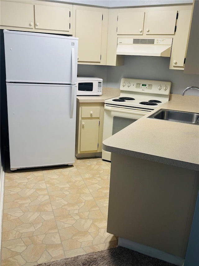 kitchen featuring cream cabinets, range hood, white appliances, and sink