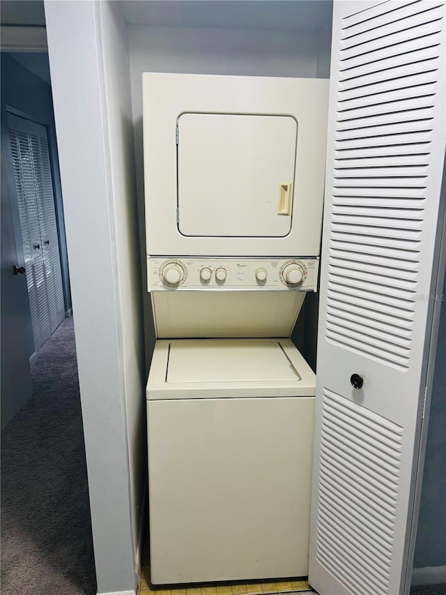 laundry room with light colored carpet and stacked washer / dryer