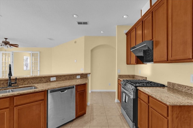 kitchen with sink, ceiling fan, light tile patterned floors, appliances with stainless steel finishes, and light stone counters