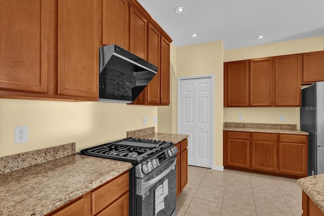 kitchen with ventilation hood, light stone counters, light tile patterned floors, and appliances with stainless steel finishes