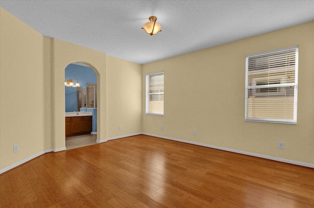 spare room featuring sink and light hardwood / wood-style flooring