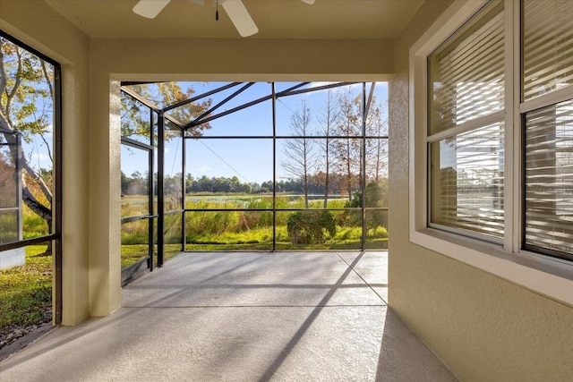 unfurnished sunroom featuring ceiling fan