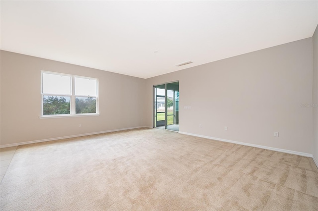 spare room featuring light colored carpet