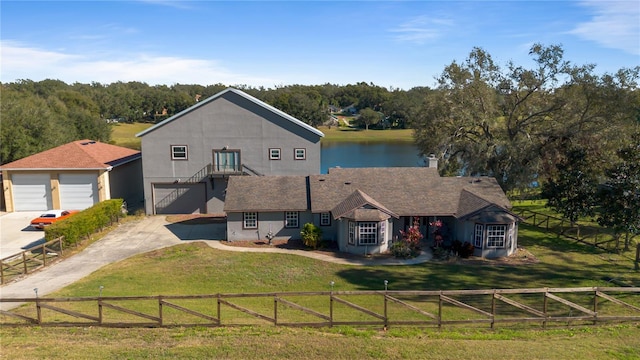 view of front of home featuring a front lawn, a water view, and a garage