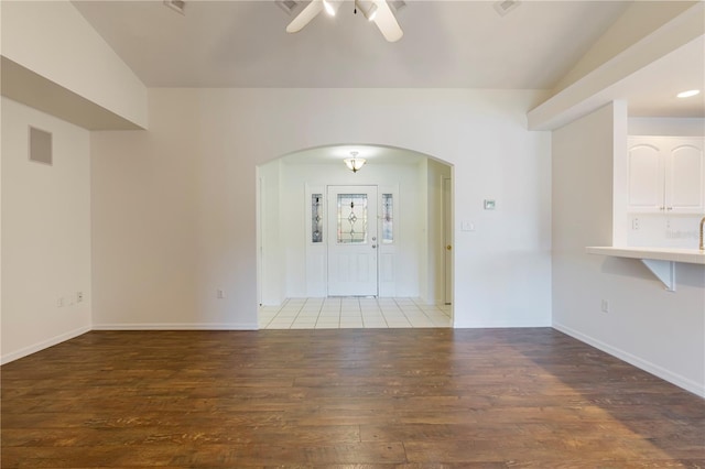 unfurnished room with ceiling fan, dark hardwood / wood-style flooring, and vaulted ceiling