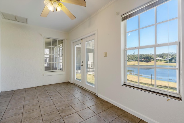 empty room with ornamental molding, a water view, light tile patterned floors, and ceiling fan