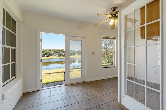 entryway with a water view, a healthy amount of sunlight, and light tile patterned floors