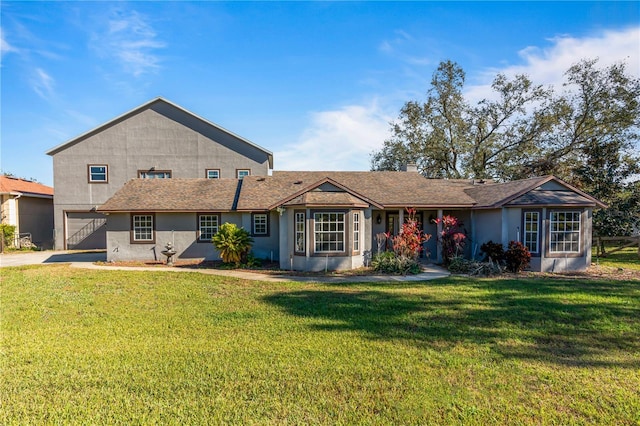 back of property with a garage and a lawn