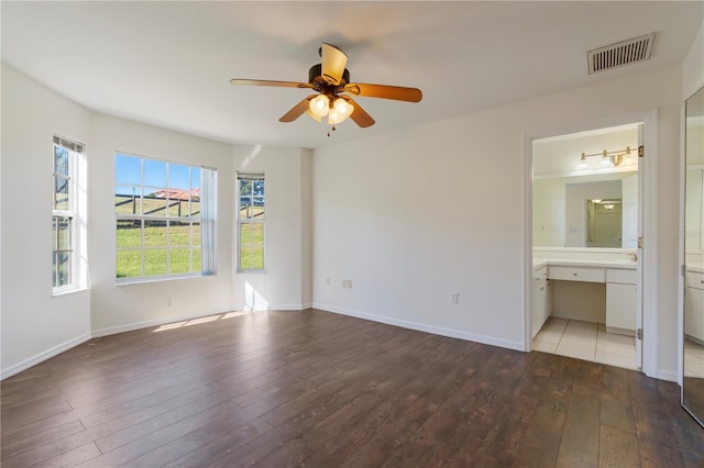 unfurnished bedroom featuring connected bathroom, hardwood / wood-style flooring, and ceiling fan