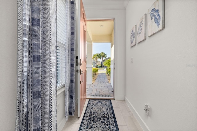 doorway to outside featuring crown molding and light tile patterned floors