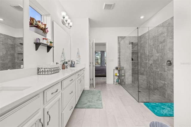 bathroom with vanity, hardwood / wood-style flooring, and a shower with door