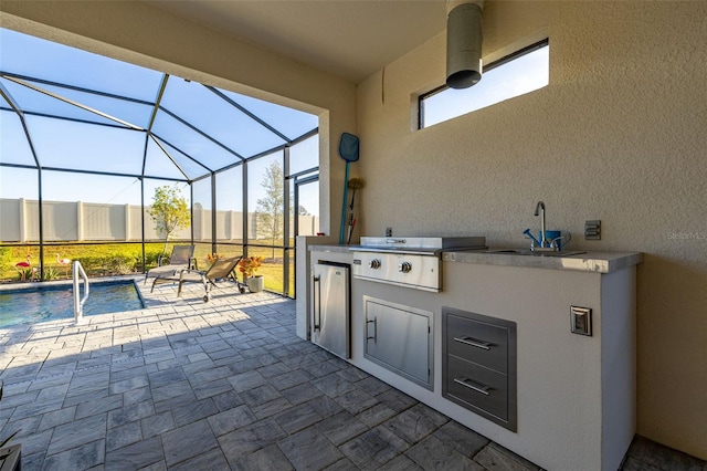 view of patio featuring grilling area, exterior kitchen, sink, and glass enclosure