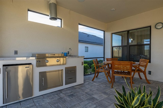 view of patio / terrace with an outdoor kitchen, area for grilling, and sink