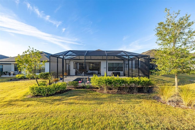 back of property with a lanai and a lawn