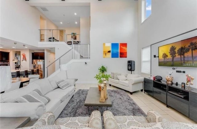 living room featuring a towering ceiling and light tile patterned flooring