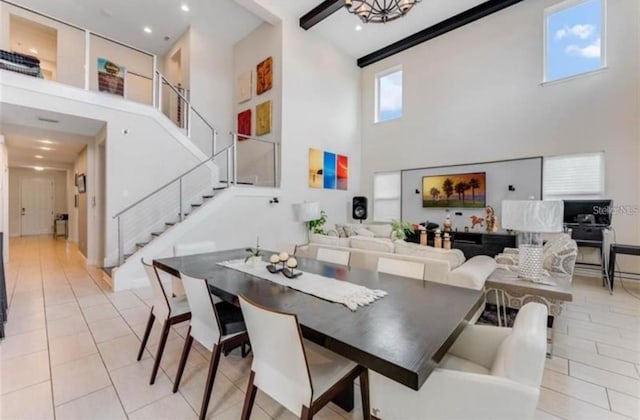 dining space with a high ceiling, an inviting chandelier, and light tile patterned floors