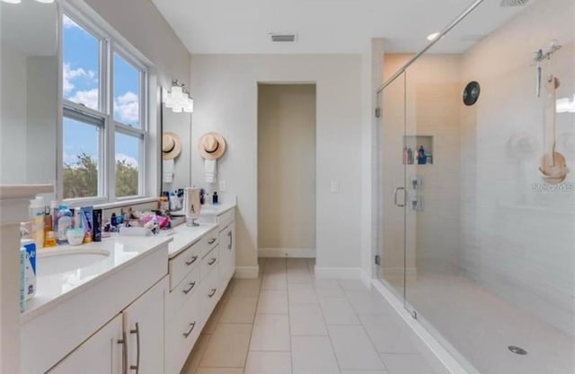 bathroom with tile patterned floors, vanity, and an enclosed shower