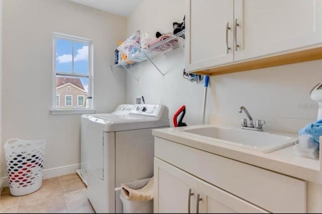 washroom with light tile patterned flooring, cabinets, sink, and washing machine and clothes dryer