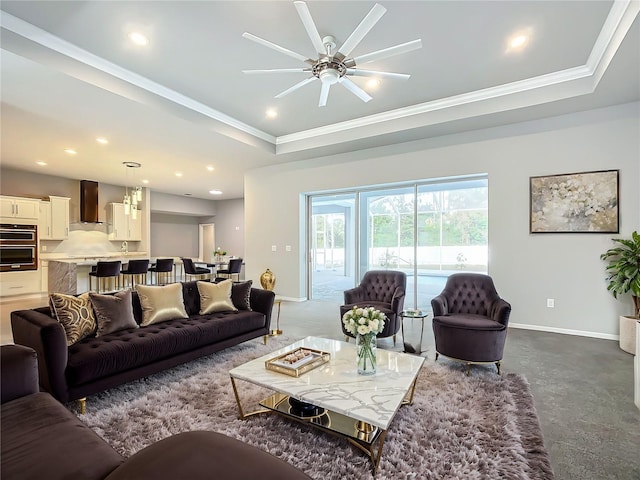 living room with a tray ceiling, ceiling fan, and ornamental molding