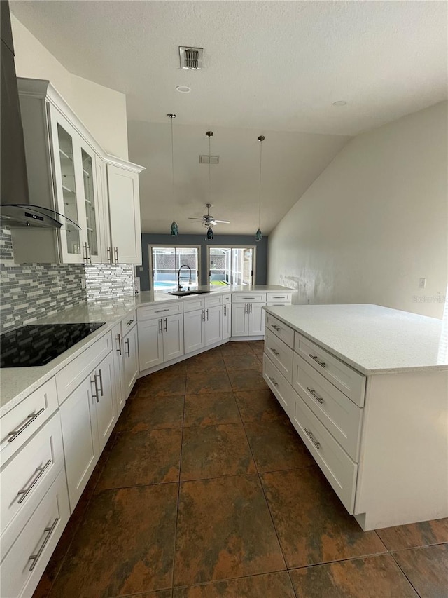 kitchen with visible vents, wall chimney range hood, black electric stovetop, decorative backsplash, and a peninsula