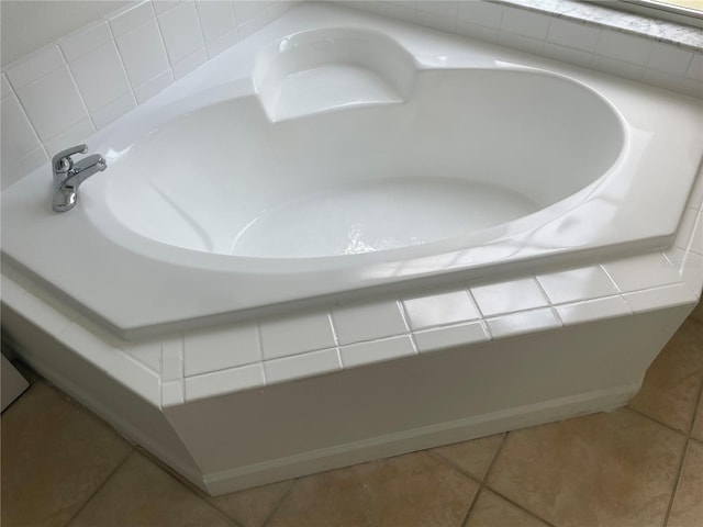 bathroom with tile patterned floors and a washtub