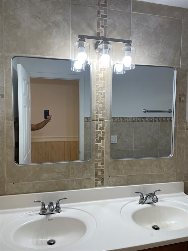 bathroom featuring a sink, tile walls, and double vanity