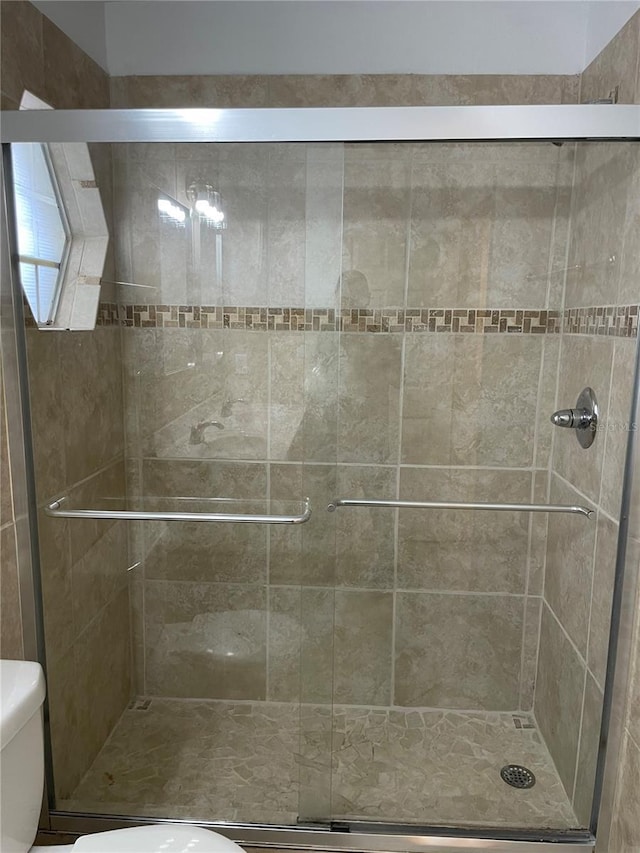 full bath with a shower stall and toilet